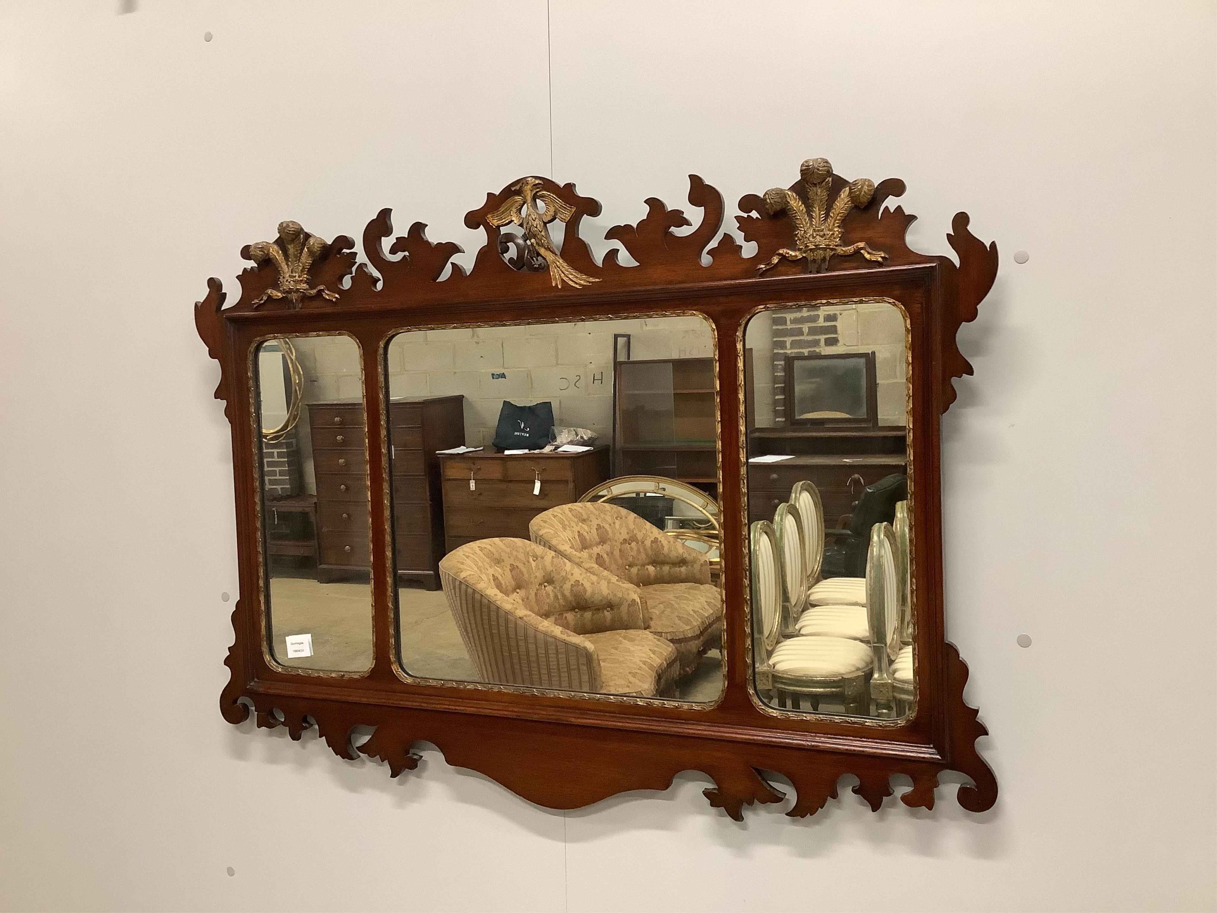 A George III style mahogany, parcel gilt triple plate fret cut wall mirror with Prince of Wales plume and phoenix pediment, width 114cm, height 84cm. Condition - fair to good